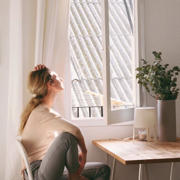 A calm woman meditating in a bright and airy room.